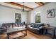 Comfortable living room with wood floors, beamed ceilings, and two large windows at 6914 Quiet Creek Dr, Bradenton, FL 34212