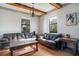 Inviting living room featuring hardwood floors, exposed beam ceilings, leather sofas and natural light at 6914 Quiet Creek Dr, Bradenton, FL 34212