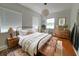 This charming bedroom features wood floors, decorative pillows, and lots of natural light from the windows at 8922 Pritcher Rd, Lithia, FL 33547
