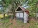 Rustic chicken coop featuring a red roof and wooden structure within a verdant, overgrown yard setting at 8922 Pritcher Rd, Lithia, FL 33547