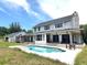 A beautiful exterior view of this multi-story home featuring a luxurious pool and outdoor living space at 8922 Pritcher Rd, Lithia, FL 33547