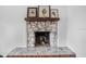 This decorative fireplace has a stone hearth and rustic wood details with pictures hanging above at 8922 Pritcher Rd, Lithia, FL 33547
