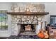 Close-up of the stone fireplace with wood mantle and guitars at 8922 Pritcher Rd, Lithia, FL 33547