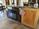 Kitchen island with granite countertop, oven, and rustic wood cabinets at 8922 Pritcher Rd, Lithia, FL 33547