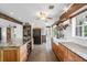An open kitchen featuring wood beams, light cabinets, a farmhouse sink, and stainless steel appliances at 8922 Pritcher Rd, Lithia, FL 33547