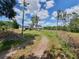 View of a two story home with a detached garage on a large lot surrounded by grass and trees at 8922 Pritcher Rd, Lithia, FL 33547