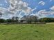 Wide angle view of property with a stone chimney surrounded by trees and green grass at 8922 Pritcher Rd, Lithia, FL 33547