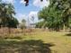 View of a two story home surrounded by wooded land, tall grasses, and green trees at 8922 Pritcher Rd, Lithia, FL 33547
