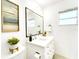Modern bathroom with white vanity, square mirror, and decorative accents at 1046 Lee St, Englewood, FL 34224