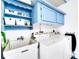 Bright laundry room with utility sink, washer, dryer and blue painted cabinets at 1046 Lee St, Englewood, FL 34224