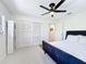 Bedroom featuring modern ceiling fan, closet with louvered doors, and bedside bookcase at 1901 Upper Cove Ter, Sarasota, FL 34231