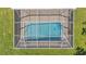 Aerial view of a screened-in backyard pool surrounded by green grass at 3517 Ralston Rd, Plant City, FL 33566