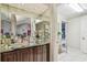 Stylish bar area featuring mirrored walls, decorative glassware, and wooden cabinetry at 8726 Tantallon Cir, Tampa, FL 33647