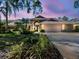 Charming single-story home featuring manicured landscaping, a three-car garage, and lush green lawn at 8726 Tantallon Cir, Tampa, FL 33647