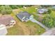 An aerial view of the green home featuring a beautiful gray roof and a gray paved driveway at 12484 Green Oak Ln, Dade City, FL 33525