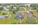 An aerial view of the neighborhood featuring the house with mature landscaping, a lake, and other residences at 12484 Green Oak Ln, Dade City, FL 33525