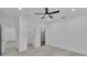 Well-lit bedroom with wood floors, ceiling fan, and access to an en-suite bathroom with glass shower at 12484 Green Oak Ln, Dade City, FL 33525