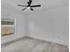 Cozy bedroom with light wood floors, ceiling fan, and plenty of natural light from the window at 12484 Green Oak Ln, Dade City, FL 33525