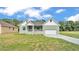 Charming single-story home featuring a well-manicured lawn and an attached two-car garage at 12484 Green Oak Ln, Dade City, FL 33525