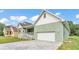 A charming home with a covered front porch and an attached two-car garage and brick paved driveway at 12484 Green Oak Ln, Dade City, FL 33525