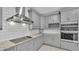 Gray kitchen with modern appliances, granite countertops, and subway tile backsplash at 12484 Green Oak Ln, Dade City, FL 33525