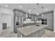 Modern kitchen featuring gray cabinets, stainless steel appliances, and granite countertops on a large island at 12484 Green Oak Ln, Dade City, FL 33525