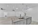 Granite kitchen island with gray cabinets and views of the open living space at 12484 Green Oak Ln, Dade City, FL 33525