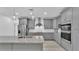 Well-lit kitchen with gray cabinets, stainless steel appliances, and a kitchen island with granite countertops at 12484 Green Oak Ln, Dade City, FL 33525