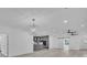 Bright open-concept living area with wood floors, modern light fixtures, and a glimpse into the stylish gray kitchen at 12484 Green Oak Ln, Dade City, FL 33525