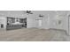 Open-concept living room with wood-look floors, a modern kitchen, and ample natural light at 12484 Green Oak Ln, Dade City, FL 33525