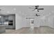 Open-concept living room featuring wood-look floors, ceiling fans, and a modern kitchen at 12484 Green Oak Ln, Dade City, FL 33525
