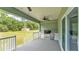 This covered patio contains an outdoor kitchen with built in appliances and ceiling fan at 12484 Green Oak Ln, Dade City, FL 33525