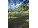 Spacious backyard featuring well-maintained grass and mature trees, near the home at 37906 Tucker Rd, Zephyrhills, FL 33542