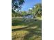 Backyard with mature trees and a shed, offering great space for outdoor activities at 37906 Tucker Rd, Zephyrhills, FL 33542