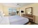 Bright bedroom with shuttered windows, rustic furniture, and wood-look floors at 605 Sutton Pl # 102, Longboat Key, FL 34228