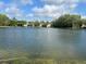 Scenic pond view reflecting the sky and community buildings, enhancing the serene environment at 3232 Lake Pine E Way # G1, Tarpon Springs, FL 34688