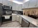 Modern kitchen features stainless steel appliances, gray cabinets, and white countertops at 3232 Lake Pine E Way # G1, Tarpon Springs, FL 34688