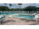 Community pool and hot tub with lounge chairs surrounded by palm trees at 3232 Lake Pine E Way # G1, Tarpon Springs, FL 34688
