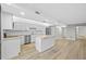 Open kitchen with white cabinets, stainless appliances, island, and light wood flooring at 3301 Bayshore Blvd # 503, Tampa, FL 33629
