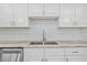 Close-up of a kitchen sink with white cabinets, subway tile backsplash, and gray marble countertops at 3301 Bayshore Blvd # 503, Tampa, FL 33629