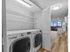 Modern laundry room with full-size washer, dryer, wire racks and bi-fold doors open to the kitchen and dining area at 3301 Bayshore Blvd # 503, Tampa, FL 33629