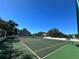 Outdoor tennis court with green surface, surrounded by fencing and lush trees, on a clear day at 3301 Bayshore Blvd # 503, Tampa, FL 33629