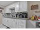 Modern kitchen featuring granite countertops, white cabinets, and tiled backsplash at 3432 Monticello St, Holiday, FL 34690