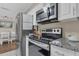 Well lit kitchen with stainless steel appliances and granite countertops, perfect for cooking and entertaining at 3432 Monticello St, Holiday, FL 34690