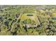 An aerial perspective showing a property with lush trees, a pond, and a home with outbuildings at 4142 El Shaddiai Sq, Plant City, FL 33565