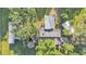 Overhead view of a home with multiple outbuildings surrounded by lush trees and a well-maintained lawn at 4142 El Shaddiai Sq, Plant City, FL 33565