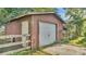 Rustic barn featuring a garage door, a side entrance, and fencing at 4142 El Shaddiai Sq, Plant City, FL 33565