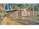 Exterior view of a rustic barn with a wooden fence, surrounded by trees and foliage at 4142 El Shaddiai Sq, Plant City, FL 33565