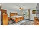 Spacious bedroom featuring a wooden bed frame, ceiling fan, and natural light from a large window at 4142 El Shaddiai Sq, Plant City, FL 33565