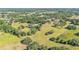 Scenic aerial view of a vast property featuring a pond, a red barn, and lush greenery at 4910 Thonotosassa Rd, Plant City, FL 33565